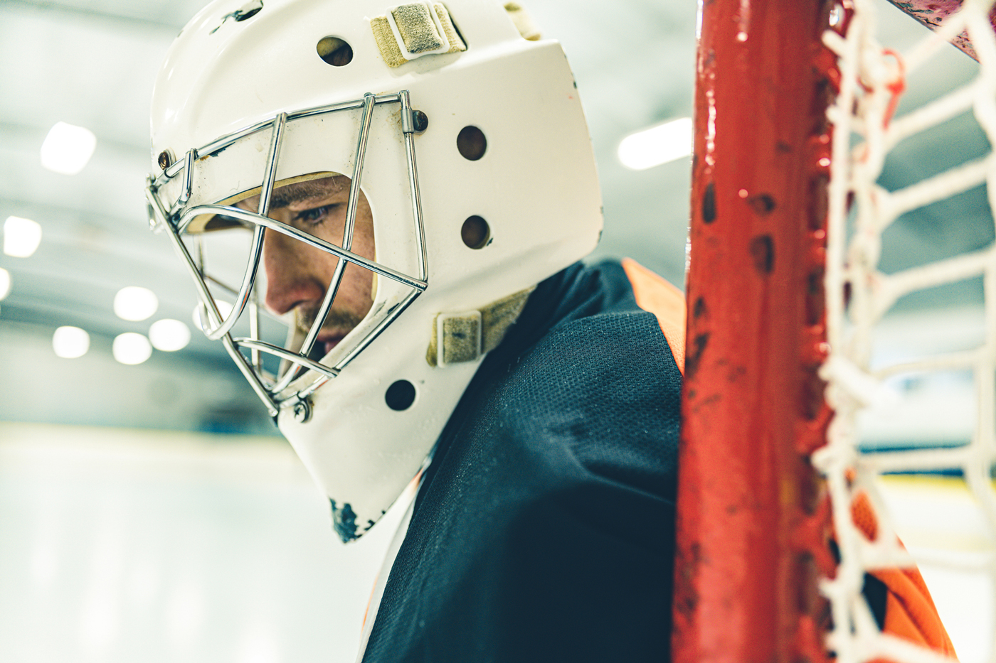 Man with ice hockey helmet in the ice rink
