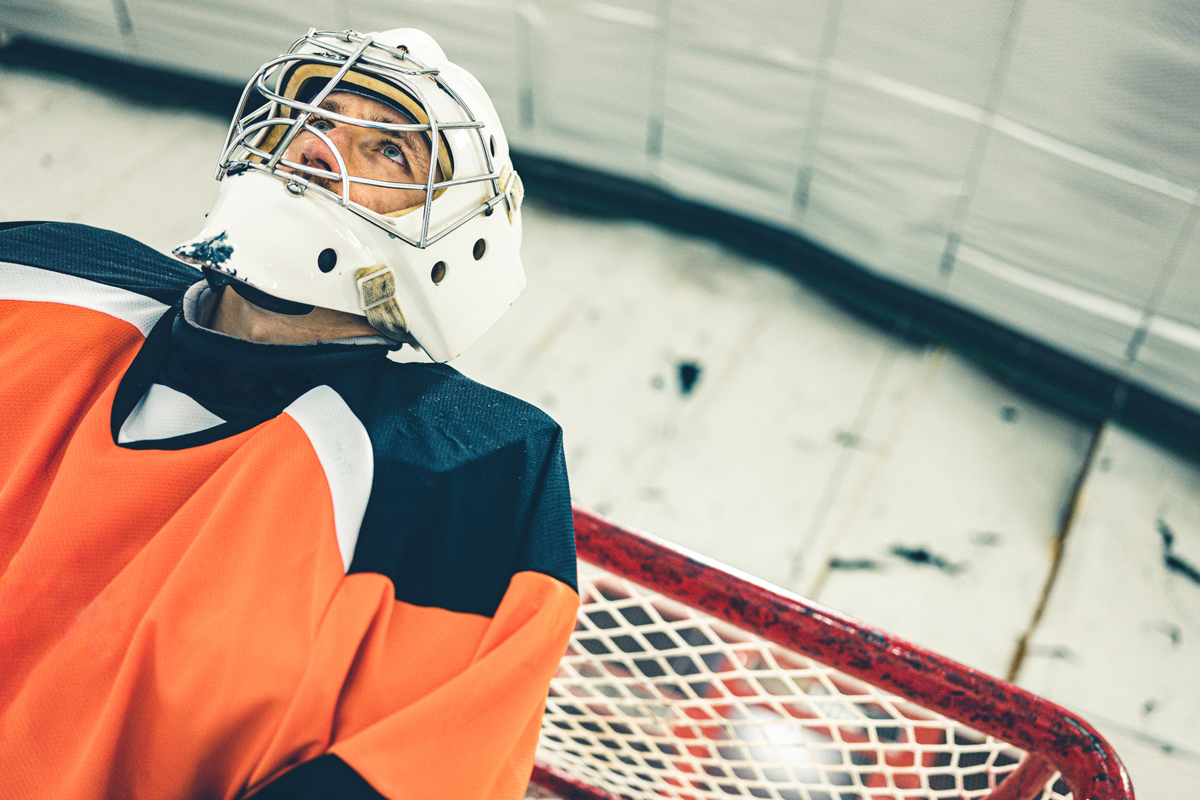 Man with ice hockey helmet in the ice rink