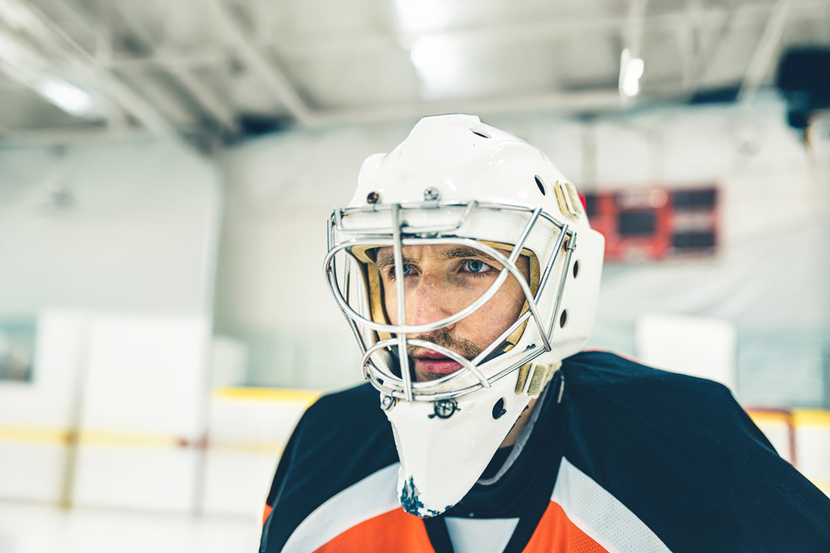 Man with ice hockey helmet in the ice rink