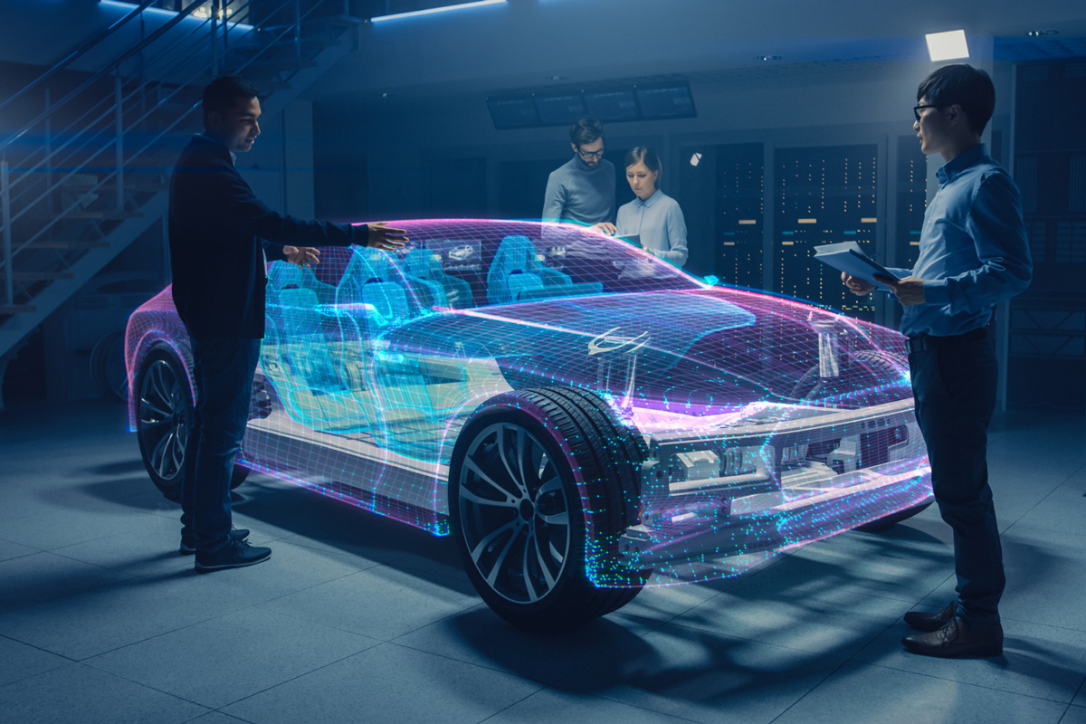 Four employees examine a virtual car (posed picture)